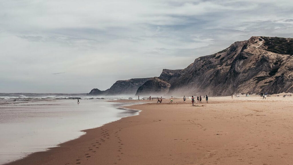 Viver em Portugal: Praia em Algarve com pessoas na areia
