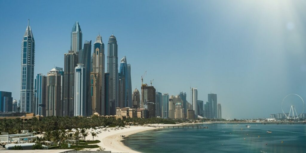 Praia com muitos prédios e palmeiras na beira da areia da praia