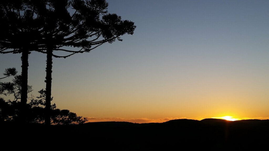 Montanhas e árvores em frente a por do sol em Campos do Jordão