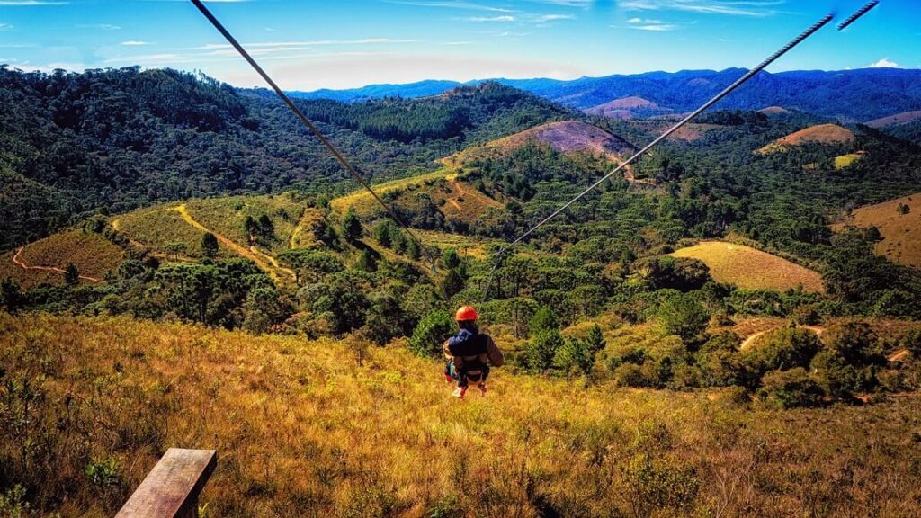 Pessoa descendo morro alto em Campos do Jordão, em uma tiroleza
