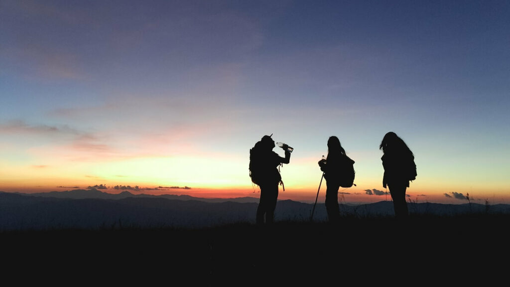 Pessoas em uma trilha no Pico de Itapeva vendo o por do sol