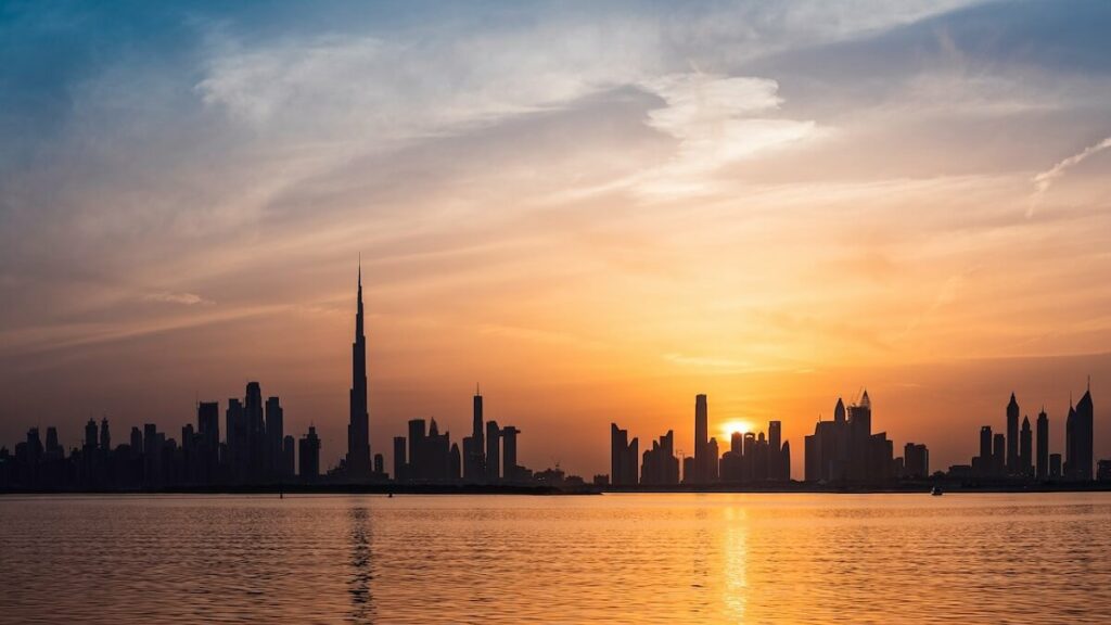 Por do sol atrás dos prédios na praia de Dubai