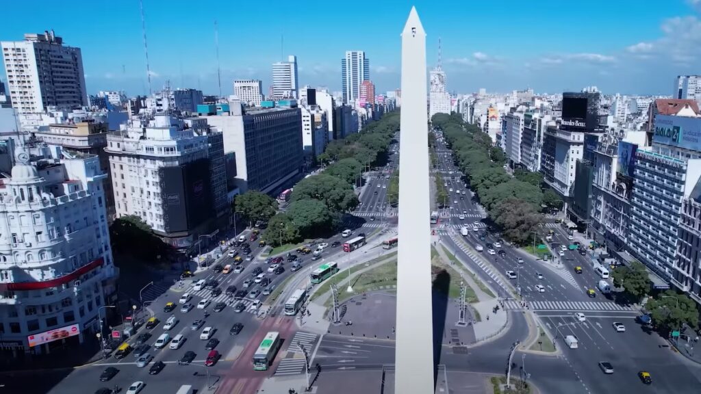 O Obelisco é uma grande estrutura branca em meio a cidade de Buenos Aires.