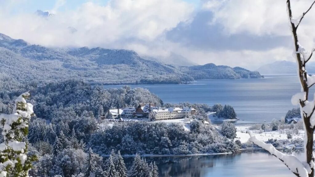 Bariloche apresenta sua região coberta de neve, a imagem traz destaque para a neve presenta na vegetação e nas estruturas locais.
