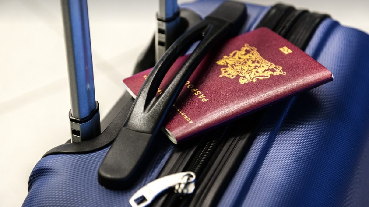 Mala de viagem azul, com um passaporte vermelho.