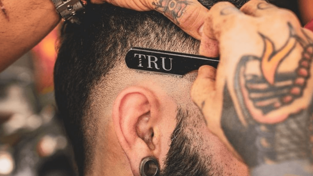 barbeiro fazendo degrade no cabelo de um homem