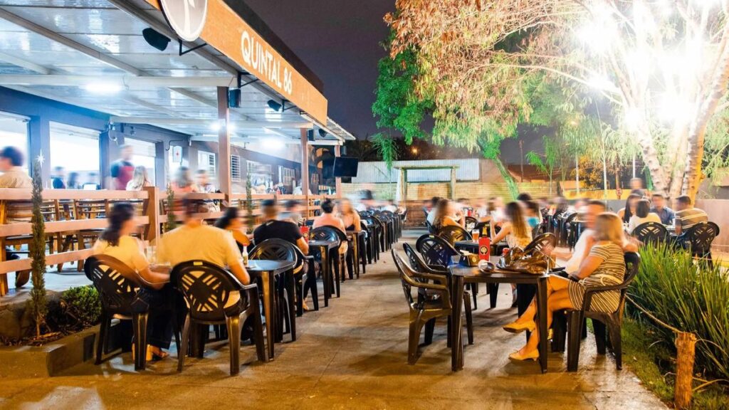 Bares em Goiânia: Um bar com muitas pessoas sentadas.