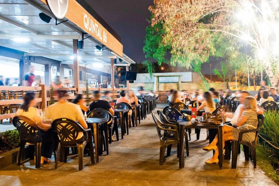 Bares em Goiânia: Um bar com muitas pessoas sentadas.