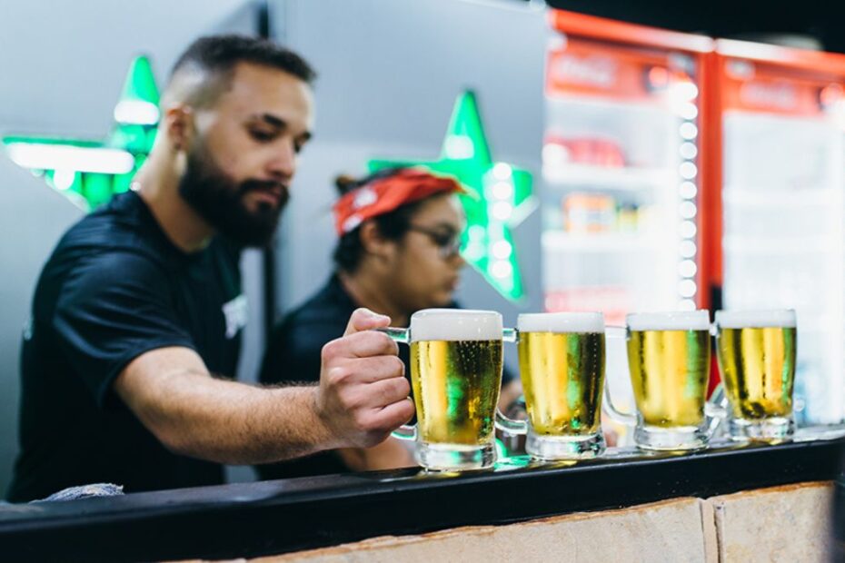 Baladas em Sorocaba: Um barman entregando cerveja no balcão.