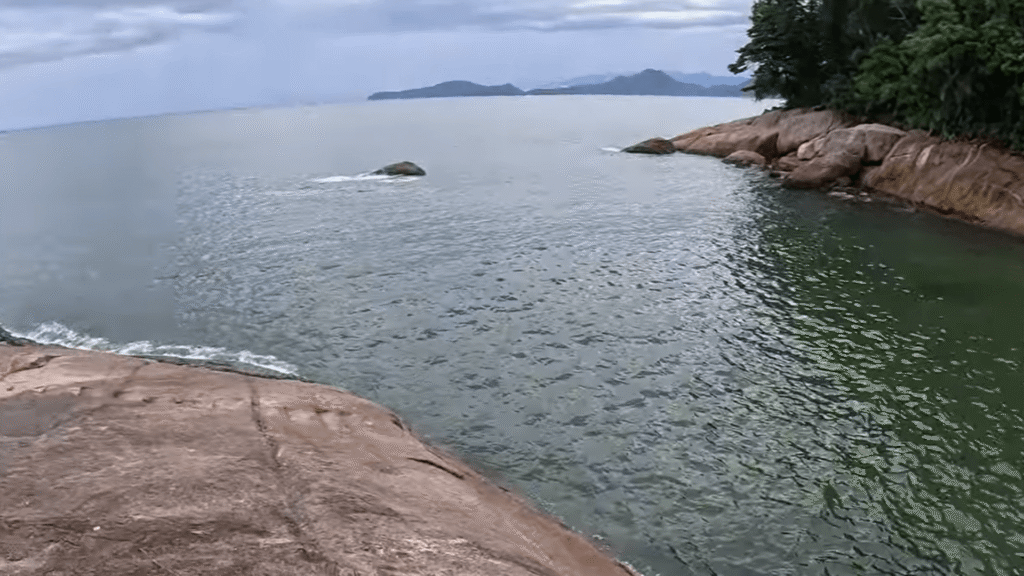 Praia do Sangava com a água bem escura.