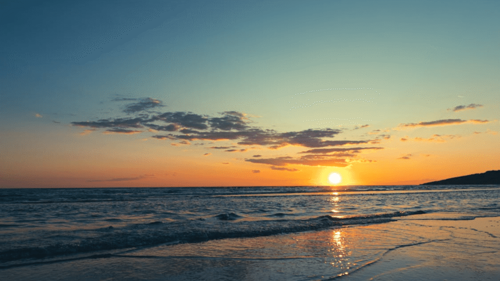 Por do sol na praia com o mar agitado na Jamaica.