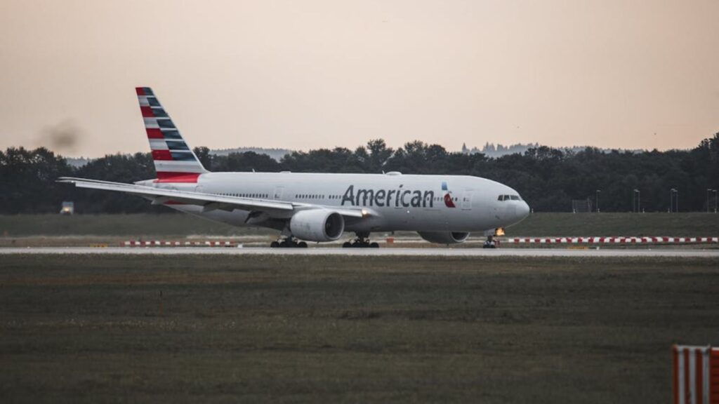 Avião subindo voo em uma pista de decolagem.