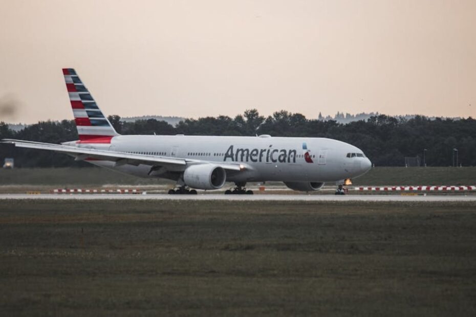 Avião subindo voo em uma pista de decolagem.